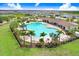 Aerial view of large community pool with lounge chairs, palm trees, and a covered seating area at 5430 Thistle Field Ct, Wesley Chapel, FL 33545