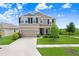 Charming two-story home featuring a well-manicured lawn, inviting entrance, and attached two car garage at 5430 Thistle Field Ct, Wesley Chapel, FL 33545