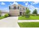 Attractive two-story home with a well-manicured lawn, complemented by lush greenery and a wide driveway at 5430 Thistle Field Ct, Wesley Chapel, FL 33545
