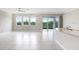 Open-concept living room with large windows, sliding doors, and tiled flooring at 5430 Thistle Field Ct, Wesley Chapel, FL 33545