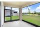 Enclosed patio with views of the lawn and lake, offering a relaxing outdoor space at 5430 Thistle Field Ct, Wesley Chapel, FL 33545