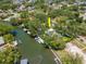 Aerial view of waterfront property featuring mature trees, dock, and boat lift at 560 Bosphorous Ave, Tampa, FL 33606