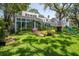 Lush backyard with a charming sunroom, brick pathway, and a custom treehouse with a slide at 560 Bosphorous Ave, Tampa, FL 33606