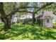 The backyard includes a well-maintained lawn, mature trees, and a quaint playhouse with swing at 560 Bosphorous Ave, Tampa, FL 33606
