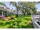 Sprawling backyard showcasing mature trees, verdant lawn, and a custom treehouse for outdoor enjoyment at 560 Bosphorous Ave, Tampa, FL 33606
