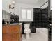 Bathroom with black tiled walls, marble floors, and a wood vanity at 560 Bosphorous Ave, Tampa, FL 33606