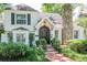 Charming two-story home with stone chimney, black shutters, arched front door and well-manicured landscaping at 560 Bosphorous Ave, Tampa, FL 33606