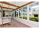 Inviting sunroom with large windows, brick floors, and a charming swing at 560 Bosphorous Ave, Tampa, FL 33606
