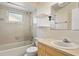 Cozy bathroom with combined tub and shower, floating shelves, and classic wallpaper at 5860 99Th N Ave, Pinellas Park, FL 33782
