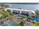Scenic aerial view of condo buildings with waterfront views, tennis courts, and parking at 615 Dream Island Pl # 210, Longboat Key, FL 34228