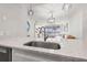 Close up of a kitchen sink with stainless steel fixtures and speckled quartz countertops at 615 Dream Island Pl # 210, Longboat Key, FL 34228