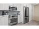Modern kitchen with stainless steel appliances, white cabinets, and light countertops at 615 Dream Island Pl # 210, Longboat Key, FL 34228