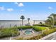 Beautiful water view featuring a hot tub, boat dock, and tropical landscaping at 615 Dream Island Pl # 210, Longboat Key, FL 34228