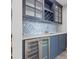 Stylish wet bar featuring a wine cooler, custom cabinetry, and a beautiful tile backsplash at 615 Dream Island Pl # 210, Longboat Key, FL 34228