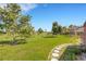 Expansive backyard featuring lush green grass, mature trees, and a charming stone pathway at 638 La Jolla Ave, Sun City Center, FL 33573