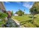 Landscaped backyard featuring a stone walkway and lush greenery, enhanced by a clear blue sky at 638 La Jolla Ave, Sun City Center, FL 33573