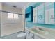 A blue bathroom with a shower and bath combination and vanity with sink, medicine cabinet and storage at 638 La Jolla Ave, Sun City Center, FL 33573