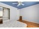 Bright bedroom with hardwood floors, featuring a spacious closet for ample storage and a ceiling fan for comfort at 638 La Jolla Ave, Sun City Center, FL 33573