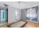 The bedroom features hardwood flooring, a ceiling fan, window with floral curtains and ensuite bathroom at 638 La Jolla Ave, Sun City Center, FL 33573