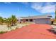 Home exterior with a painted red driveway, gray brick, red shutters, and a two-car garage at 638 La Jolla Ave, Sun City Center, FL 33573