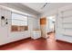 A spacious garage with red epoxy flooring, white walls, shelving and window with AC unit at 638 La Jolla Ave, Sun City Center, FL 33573