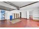 Spacious garage with a red floor and shelving, complete with an automatic door and access to the kitchen at 638 La Jolla Ave, Sun City Center, FL 33573
