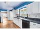 Well-lit kitchen features classic white cabinetry, black countertops, and a window overlooking the yard at 638 La Jolla Ave, Sun City Center, FL 33573