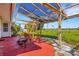 Relaxing covered patio with a cozy swing and red painted concrete, perfect for enjoying the outdoors at 638 La Jolla Ave, Sun City Center, FL 33573