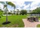 Expansive backyard with lush green lawn, patio furniture, and mature trees, perfect for outdoor activities and relaxation at 7725 235Th E St, Myakka City, FL 34251