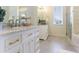Bright bathroom featuring double vanities, marble countertops, gold hardware, and a separate glass shower enclosure at 7725 235Th E St, Myakka City, FL 34251
