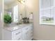 Bright bathroom featuring vanity with marble countertops, gold hardware, decorative mirror and a window at 7725 235Th E St, Myakka City, FL 34251