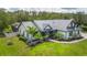 Beautiful white home featuring a metal roof and lush landscaping at 7725 235Th E St, Myakka City, FL 34251