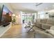 Comfortable living room with neutral tones, wood floors, and sliding glass doors at 7725 235Th E St, Myakka City, FL 34251