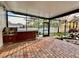 Covered outdoor kitchen and patio space featuring a grill, cabinetry, and brick pavers for outdoor cooking and entertaining at 7725 235Th E St, Myakka City, FL 34251