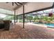 Stunning screened pool area with rock waterfall feature, complemented by comfortable seating and lush landscaping for outdoor relaxation at 7725 235Th E St, Myakka City, FL 34251