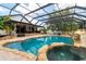 Inviting in-ground pool with rock waterfall, spa, and lush landscaping, all within a screened enclosure for year-round enjoyment at 7725 235Th E St, Myakka City, FL 34251