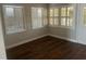 Bedroom featuring wood-look floors, three windows with shutters, and neutral wall paint at 8033 55Th E St, Palmetto, FL 34221