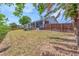 Spacious backyard featuring a wooden fence, large trees, and a screened-in patio at 832 Birdie Way, Apollo Beach, FL 33572