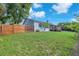 Spacious backyard with a lush green lawn, wooden fence, and partial view of the home at 832 Birdie Way, Apollo Beach, FL 33572