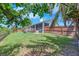 Spacious backyard with a deck, patio, lush lawn, and secure wood privacy fence at 832 Birdie Way, Apollo Beach, FL 33572