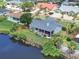 Aerial view of a home's screened lanai, set along a waterfront with lush green backyard at 832 Birdie Way, Apollo Beach, FL 33572