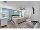 Bright bedroom with a ceiling fan, blue accent wall, and sliding glass door to a balcony at 832 Birdie Way, Apollo Beach, FL 33572