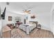 Cozy bedroom features a ceiling fan, desk, and comfortable bed on stylish wood-look flooring at 832 Birdie Way, Apollo Beach, FL 33572