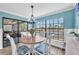 Cozy dining area with waterfront views, chandelier, and slider out to the screened porch at 832 Birdie Way, Apollo Beach, FL 33572