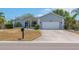 Charming single-story home with a two-car garage, manicured landscaping, and a well-maintained lawn at 832 Birdie Way, Apollo Beach, FL 33572