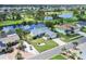 Aerial view of a single-story home with manicured lawn, lush landscaping, and water view at 832 Birdie Way, Apollo Beach, FL 33572