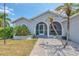 Inviting home exterior featuring a cozy front porch, mature landscaping, and a welcoming entrance at 832 Birdie Way, Apollo Beach, FL 33572