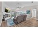 Open-concept living room with a fireplace, TV, comfortable seating, and access to outdoor patio at 832 Birdie Way, Apollo Beach, FL 33572