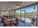 Enclosed lanai features comfortable seating, view of the lake, and ceiling fans at 832 Birdie Way, Apollo Beach, FL 33572