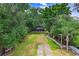 Lush backyard leads to a waterfront view with a cozy tiki hut, perfect for enjoying the outdoors and waterfront living at 8903 Donna Lu Dr, Odessa, FL 33556